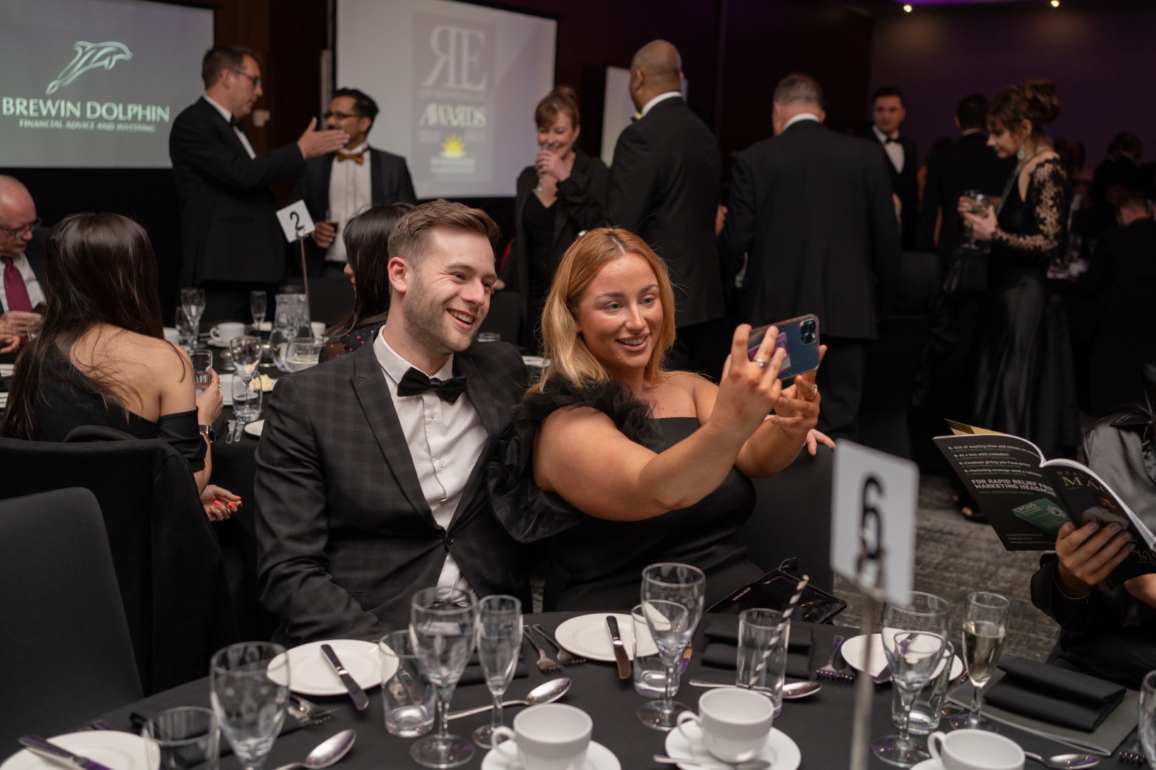 Guests take a selfie at a dinner table at the Real Entrepreneurs' Awards 2022