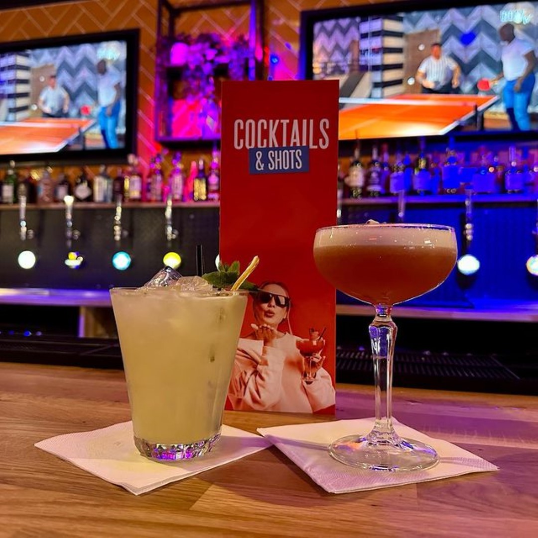 A yellow and a red cocktail on the bar at Roxy Ball Room in Leicester