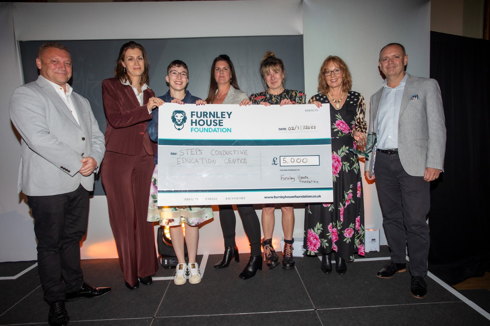 Furnley House Leicester Community Champion Awards winners gayher with giant check for charity winner