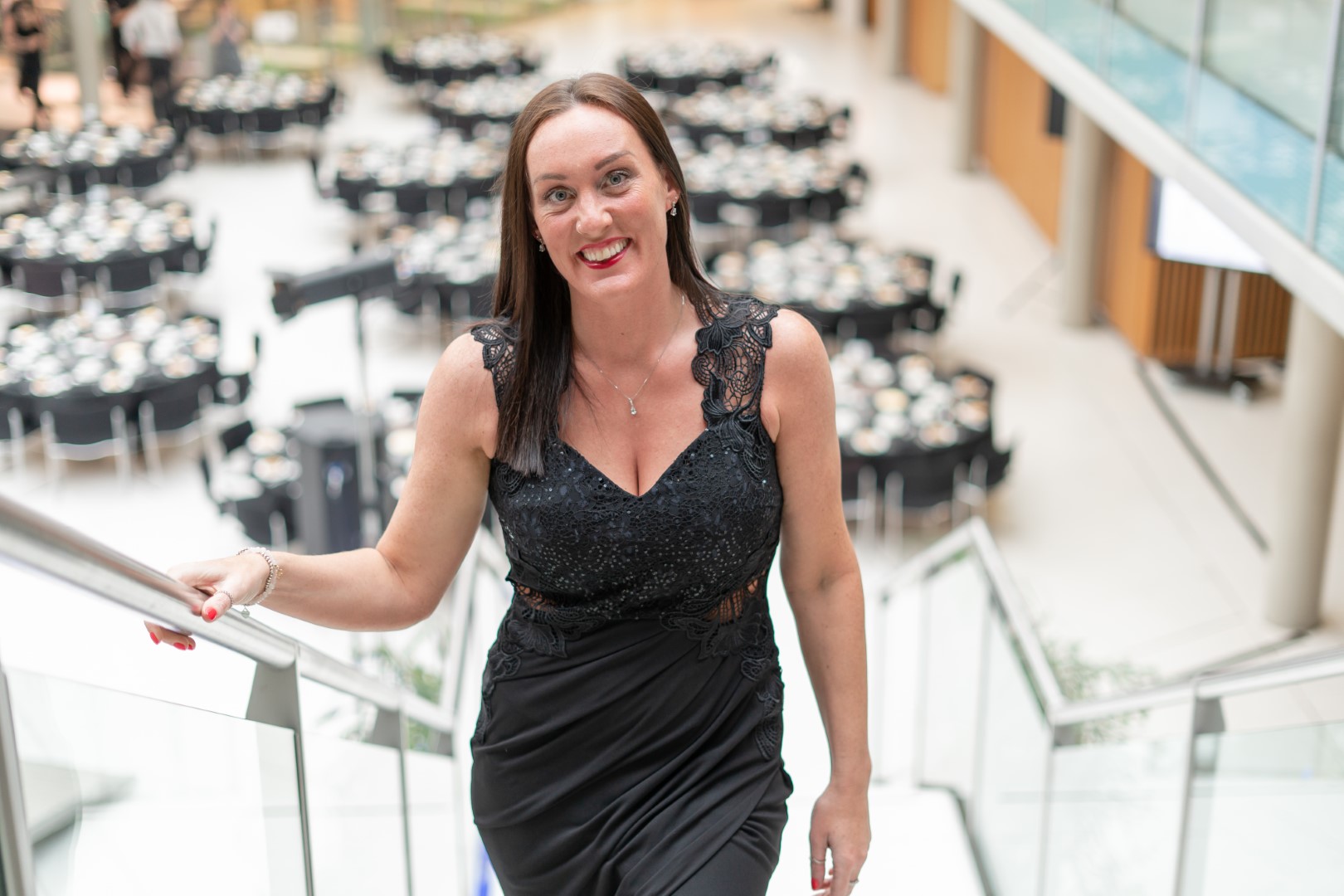 Cross Productions CEO Jenny Cross wears a black dress and walks up the stairs