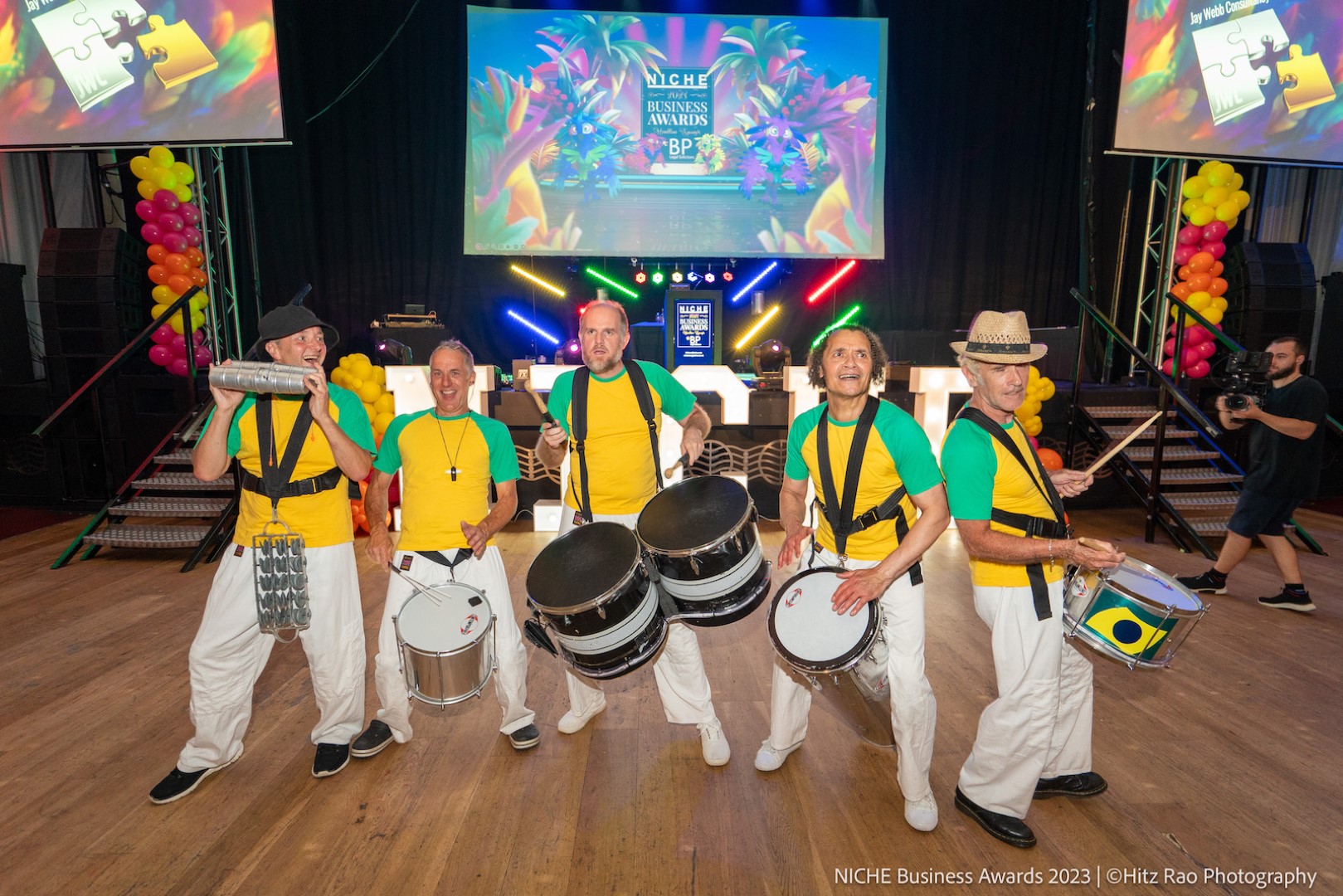 drummers wearing white trousers and yellow and green t-shirts